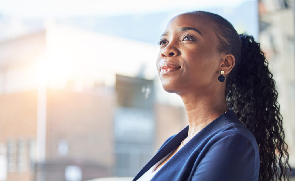 Office professional deep in thought looking out of frame by window